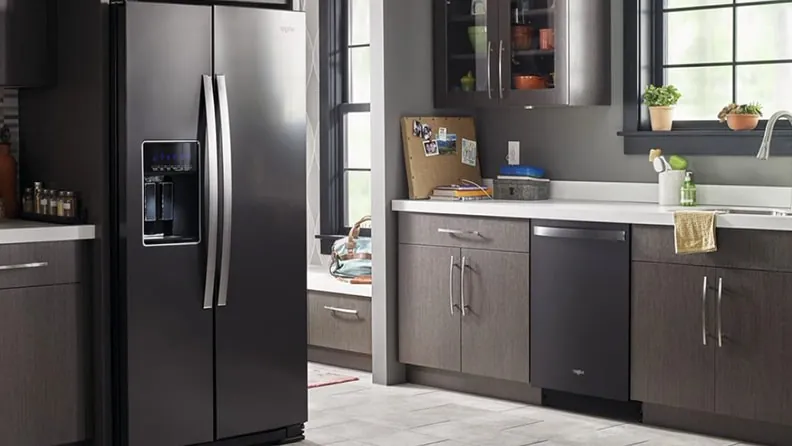 Cleaning dusty condenser coils behind a refrigerator kick plate to extend its life