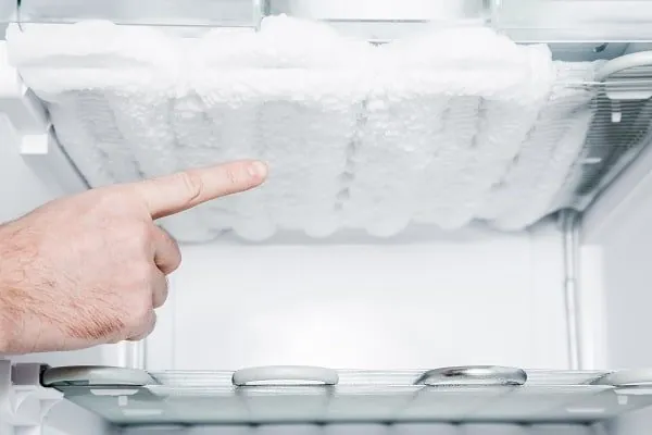 Glass thermometer on counter with open freezer in background