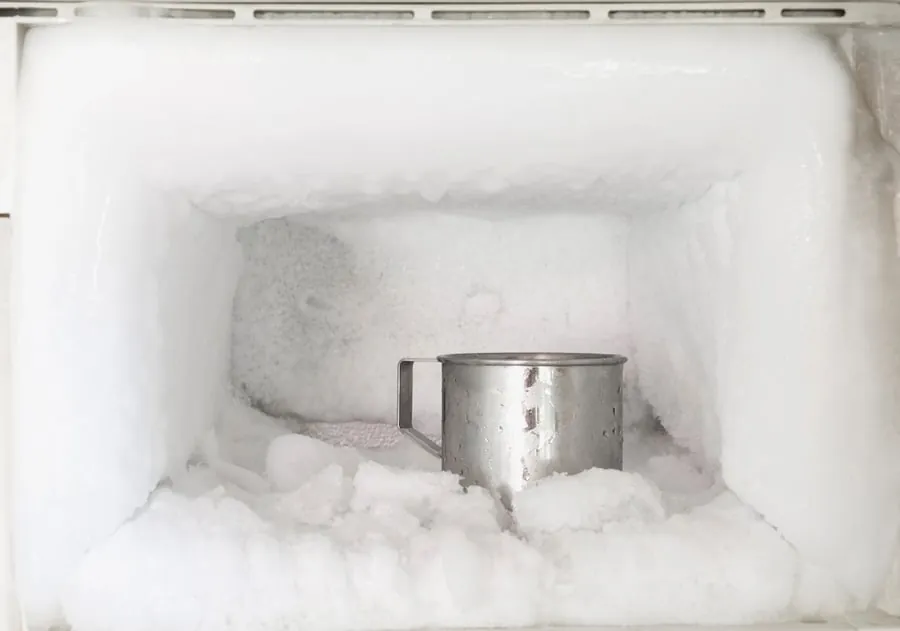 Hand closing freezer door to prevent frost from returning