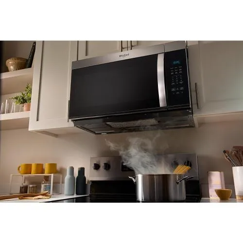 Hand gently closing a microwave door on a tidy counter