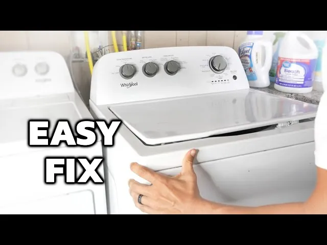 Hand pressing down the lid of a top-load washing machine