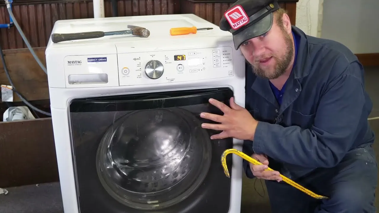 Hand unplugging washing machine power cord from wall outlet