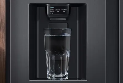 Hand wiping the locked dispenser panel on a Samsung fridge