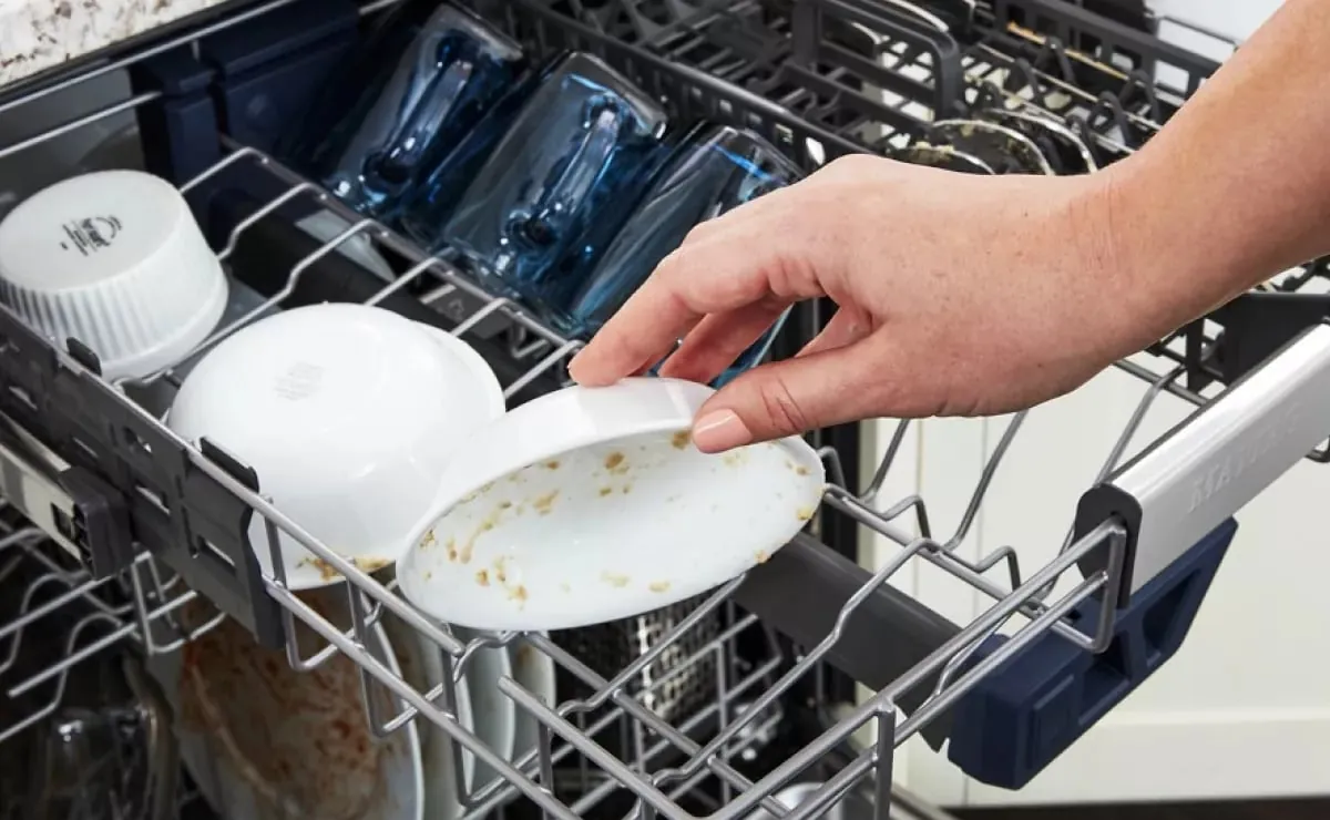 Hands holding dishwasher spray arm with light through holes