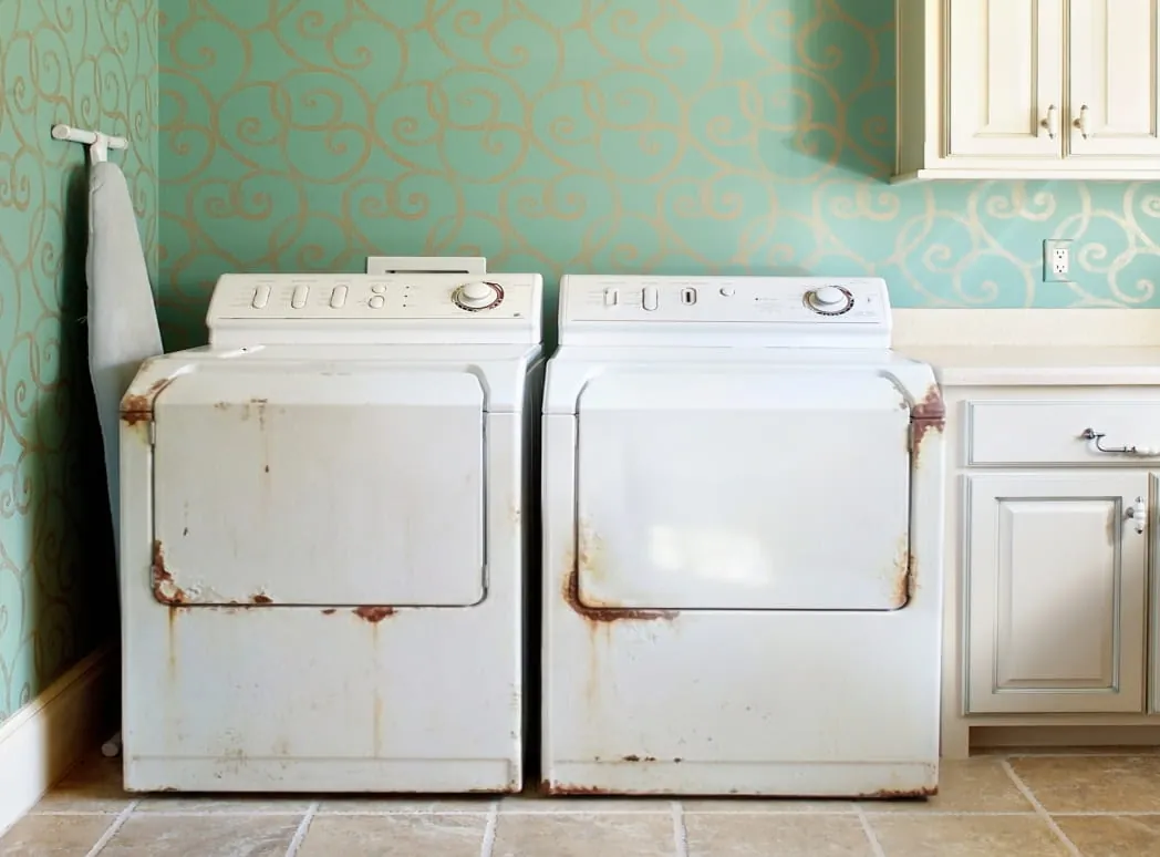 Hands using a spirit level on a stackable washer and dryer