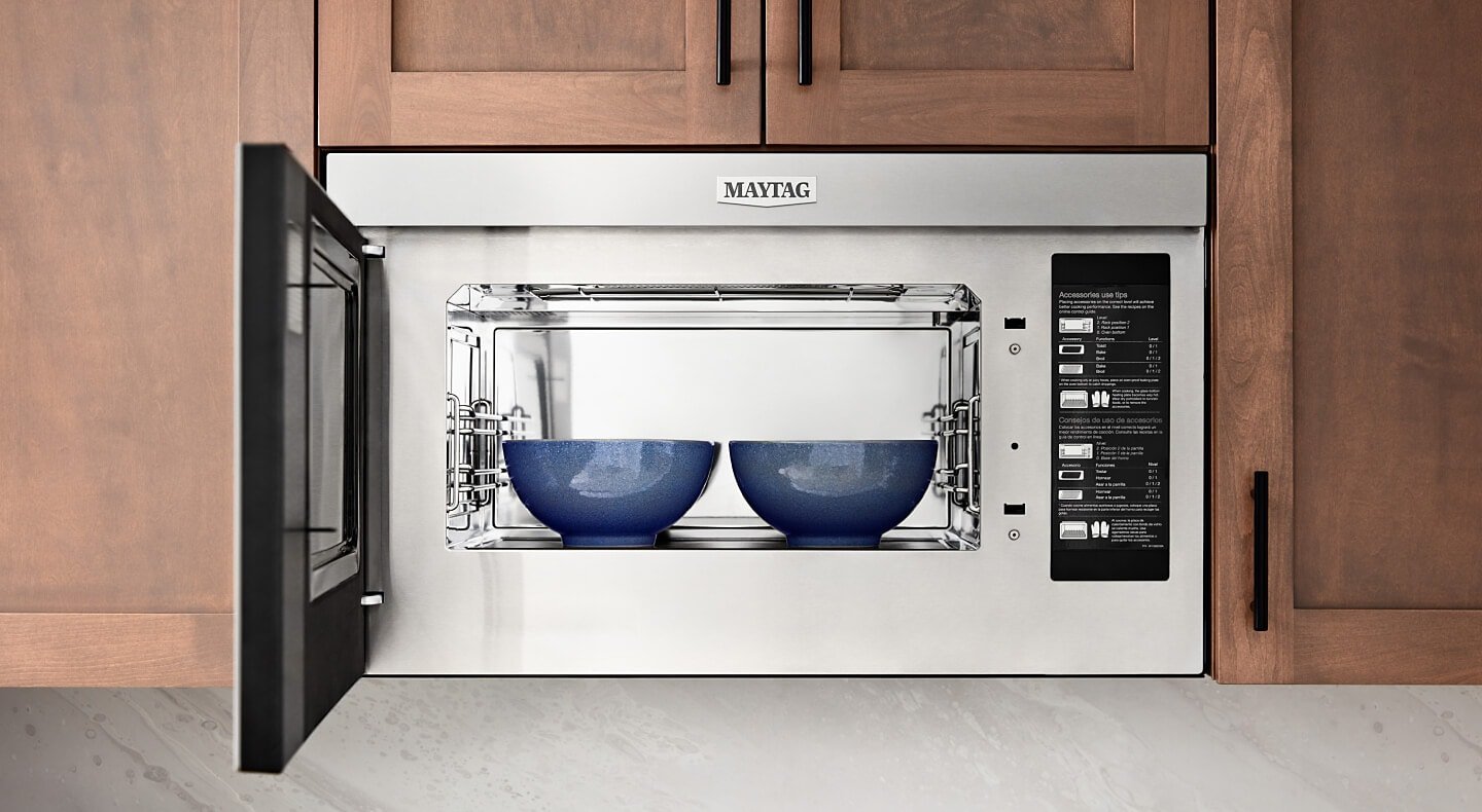 Open microwave with unplugged cord on a kitchen counter