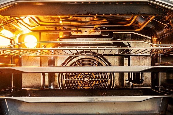 Open oven with a dark heating element in a modern kitchen