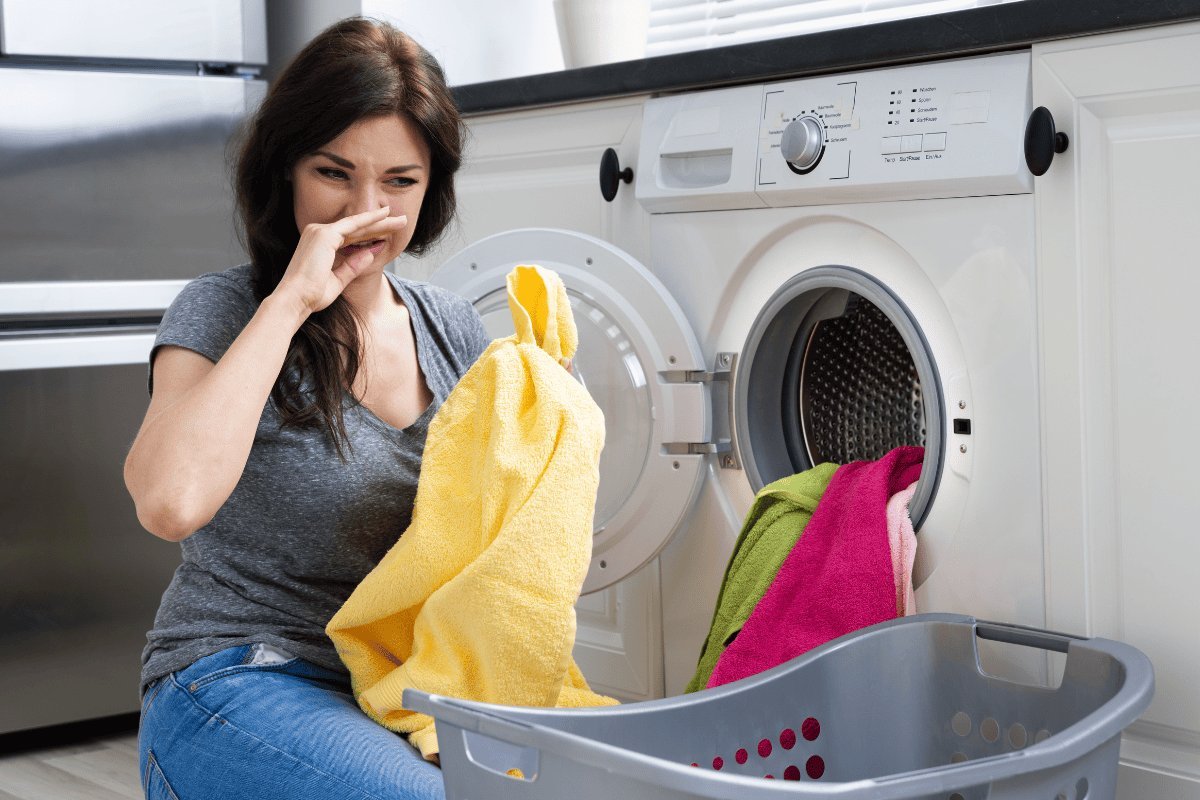 Open washing machine and laundry basket showing why clothes smell after drying