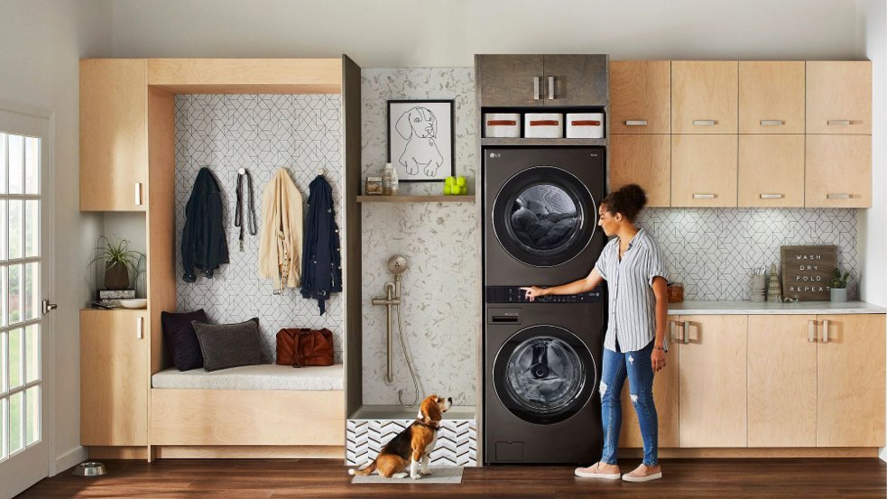 Stackable washer and dryer unit in a modern laundry closet with natural light