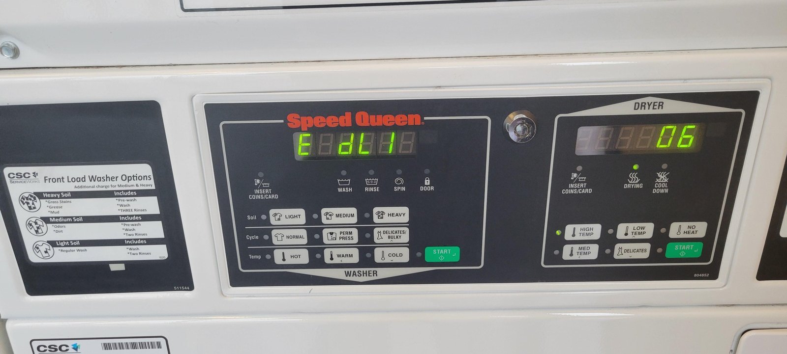 White top-loading washer in a bright laundry room with a hand near the lid